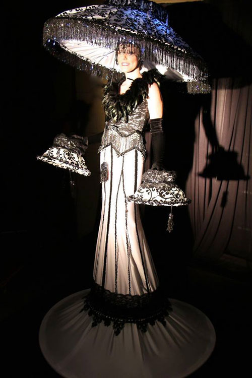 Ert style costume with lit-from-within shade, on stilts.